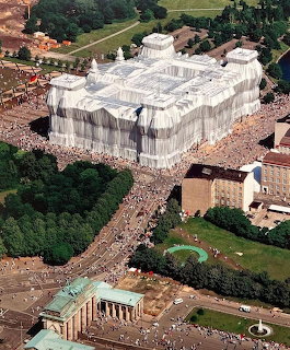 Aerial photo of the wrapped Reichstag building in Berlin with crowds and Brandenburg Gate visible