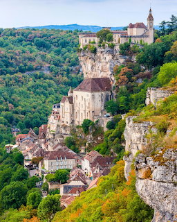 Historic village of Rocamadour perched on steep cliffs above forested valley in France