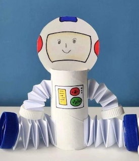 Handmade paper roll robot craft with accordion arms, bottle cap hands, and drawn face
