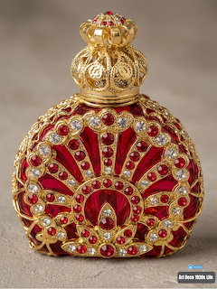 Ornate ruby red perfume bottle with gold filigree and jewels