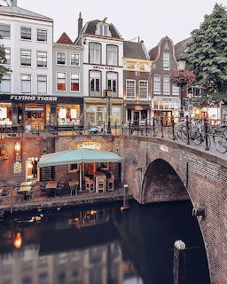 Brick bridge and canal houses beside a Dutch canal with evening reflections in the water