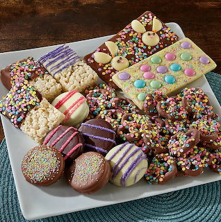 Assorted chocolate desserts with colorful sprinkles on white plate