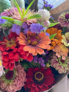 Colorful bouquet of zinnias, dahlias and assorted garden flowers in bright red, orange, purple and pink hues