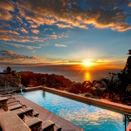 Infinity pool with lounge chairs overlooking the ocean at sunset