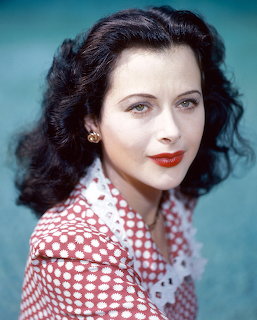 Color portrait of Hedy Lamar with dark wavy hair, red lips, and polka dot blouse