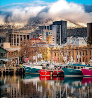 Colorful boats in Hobart harbour with mountain backdrop
