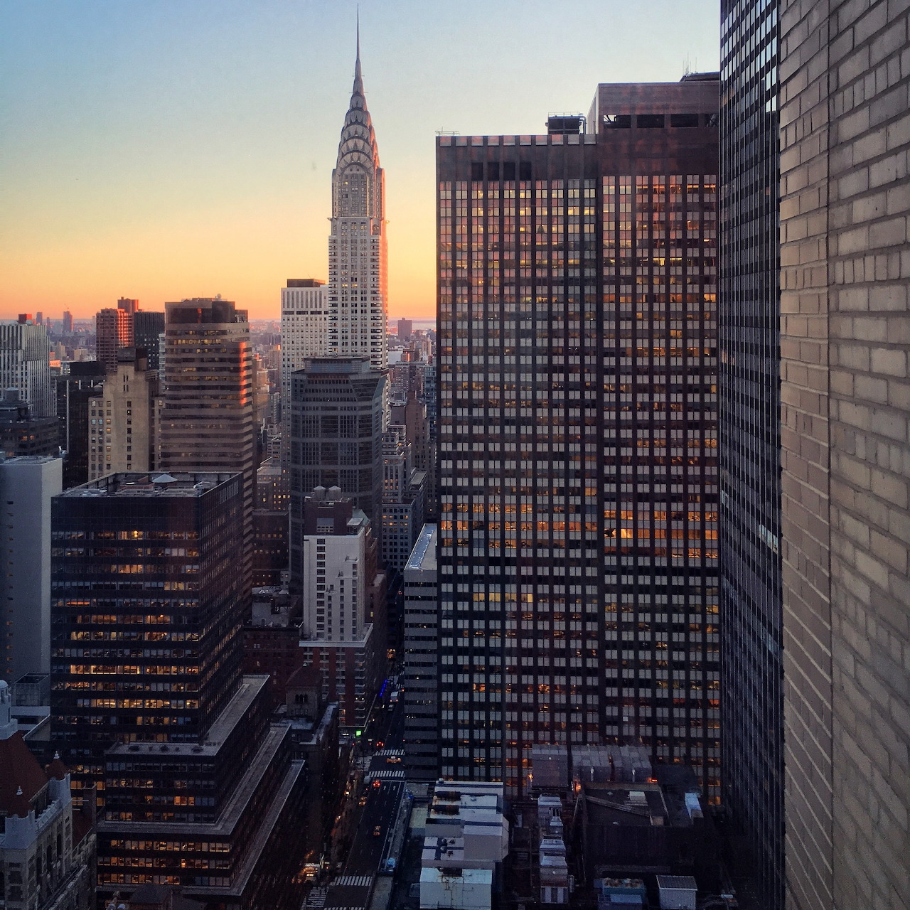 Manhattan skyline at sunset showing Chrysler Building and Turtle Bay high-rises with warm golden sky