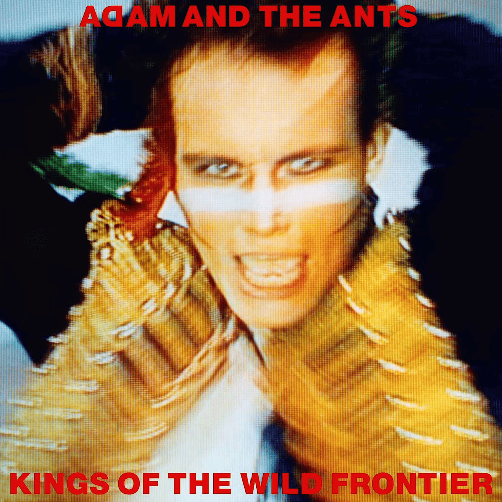 Album cover with a close-up portrait, dramatic makeup, ornate costume, and red band text