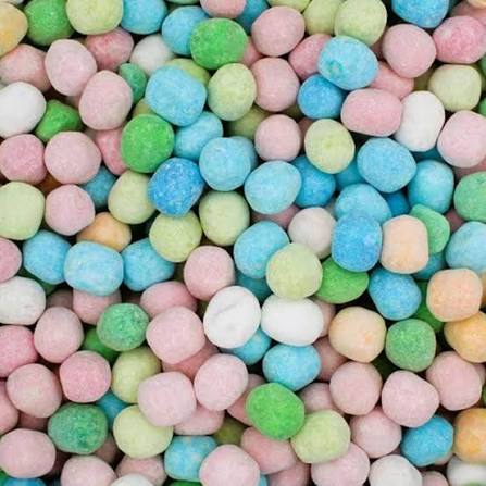 Scattered pastel candy balls in pink, blue, green, yellow, and white colors