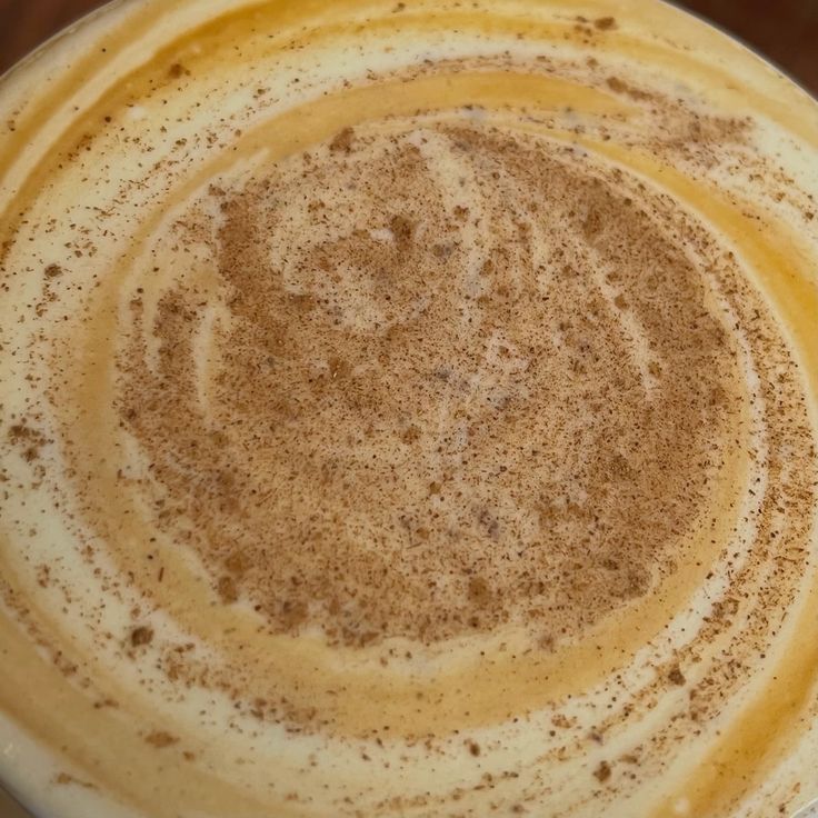 Top view of a latte with cinnamon sprinkled over milk foam