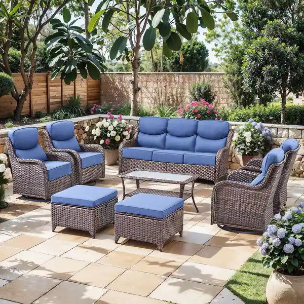 Outdoor wicker patio furniture set with blue cushions on a tiled garden patio