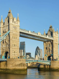 Tower Bridge over Thames River with London skyline and blue sky