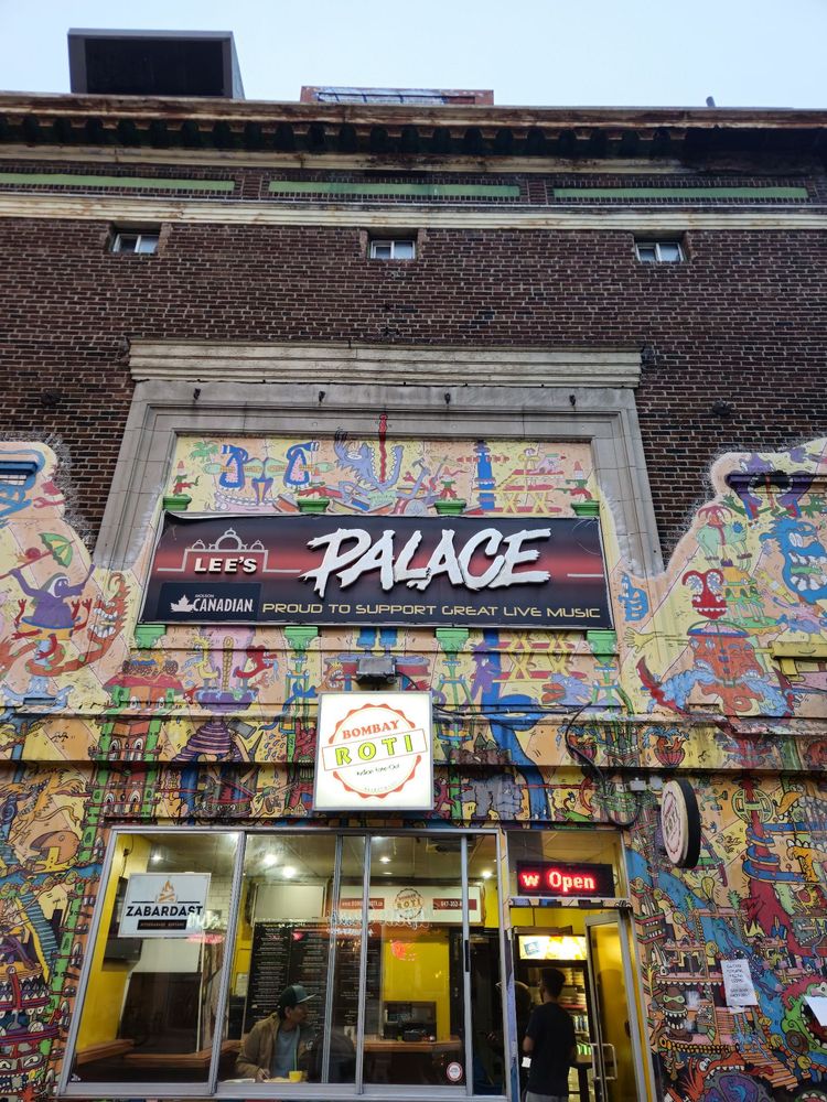 Lee's Palace music venue exterior with vibrant street art murals covering brick walls