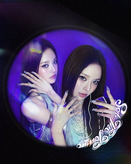 Two young women posing together through a circular frame with purple lighting