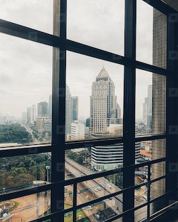 City skyline viewed through large grid windows from inside a building