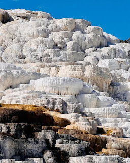 White limestone terraces with orange mineral staining at Mammoth Hot Springs geothermal formation