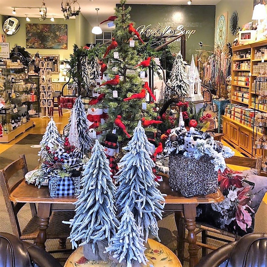 Christmas store display with decorated trees and holiday ornaments on wooden tables