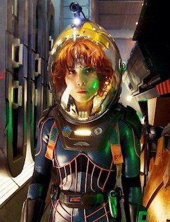 Woman in futuristic space suit holding helmet in dark sci-fi spacecraft corridor with green lighting