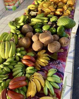 Vibrant display of tropical fruits including bananas, papayas, and other produce at a market stall