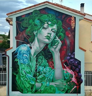 Street art mural of woman with green wavy hair wearing teal jacket against red and green swirling background