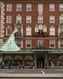 Fortnum & Mason department store facade in London with green awnings and decorative clock