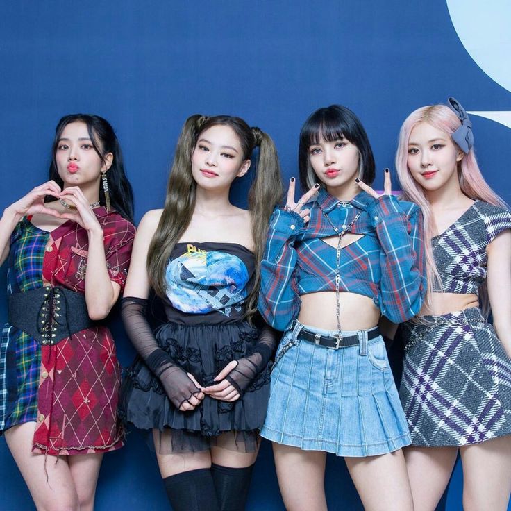 Four BLACKPINK members posing in plaid outfits against a blue backdrop