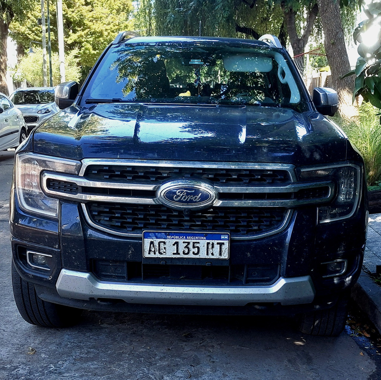 Front view of a black Ford Ranger parked on a shaded street