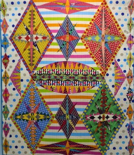 Geometric quilt with diamond shapes, indigenous patterns, colorful stripes and polka dots on white background