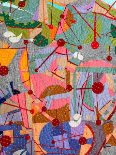 Colorful abstract patchwork quilt with birds, geometric shapes, and intricate stitching patterns