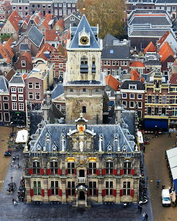 Aerial view of Delft Town Hall with its tower surrounded by traditional Dutch buildings and red roftops