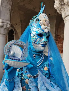 Turquoise Venice carnival costume with pearl shell theme and ornate mask under stone arches