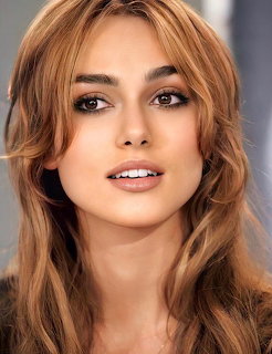 Portrait of Keira Knightley with long wavy brown hair looking at camera