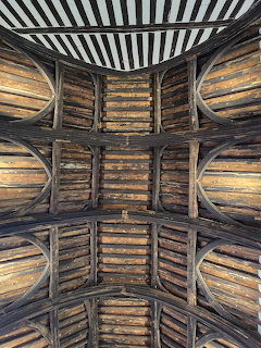 Historic medieval timber ceiling with curved wooden beams and arched structural supports in Gainsborough Hall