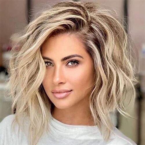 Portrait of a woman with shoulder-length wavy blonde hair and soft makeup