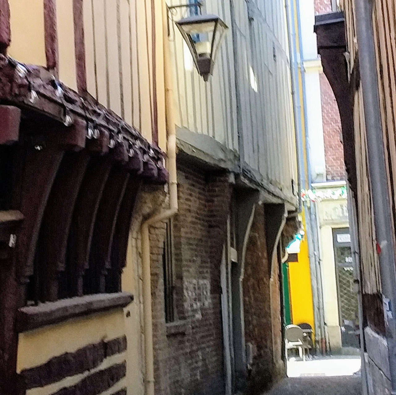 Narrow historic alley lined with old timber and brick buildings in Rouen, Normandy