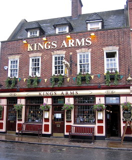 Red brick Kings Arms pub facade on a rainy street in England