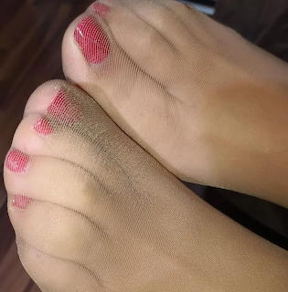Close-up of feet with red painted toenails under sheer mesh stockings