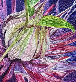 Close-up of a flower bud and leaf in a colorful quilted textile artwork