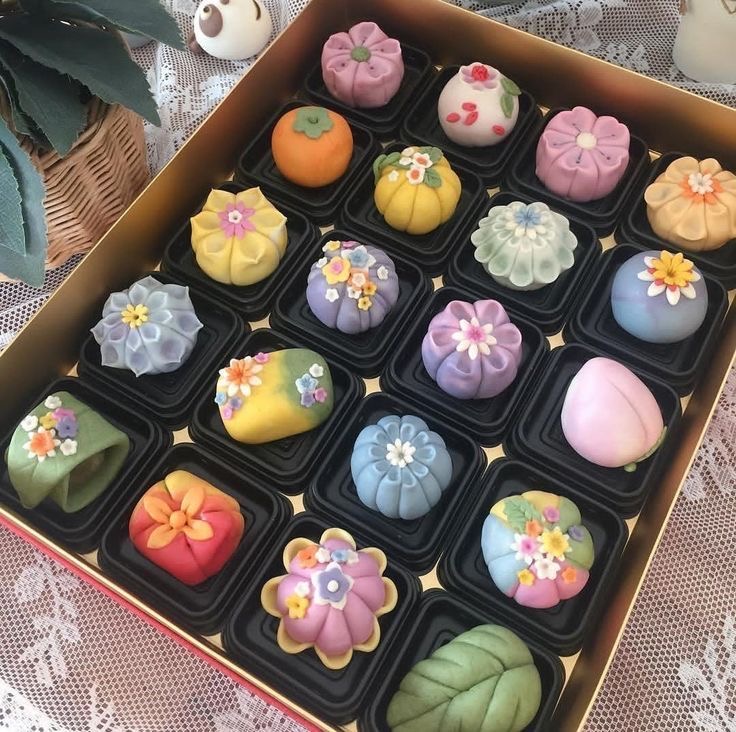 Box of colorful Japanese mochi decorated with flowers and pastel designs