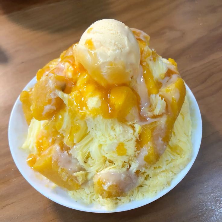 Mango bingsu shaved ice dessert with mango topping and ice cream scoop