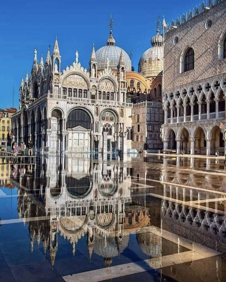 St. Mark's Basilica and Doge's Palace with perfect reflection in flooded Venice square