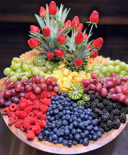 Round fruit platter with grapes, raspberries, blueberries, blackberries, pineapple, and strawberries