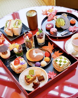 Japanese afternoon tea set with assorted sweets, wagashi, and desserts in red and black lacquer boxes