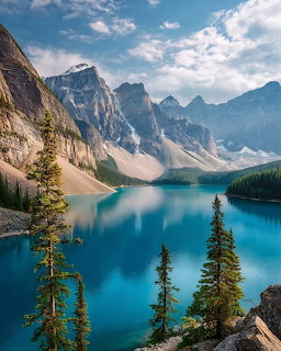 Turquoise Moraine Lake surrounded by dramatic rocky mountains and pine trees under a cloudy sky