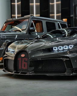 Black Bugatti Chiron supercar with red 16 on grille parked in a modern showroom next to a dark SUV