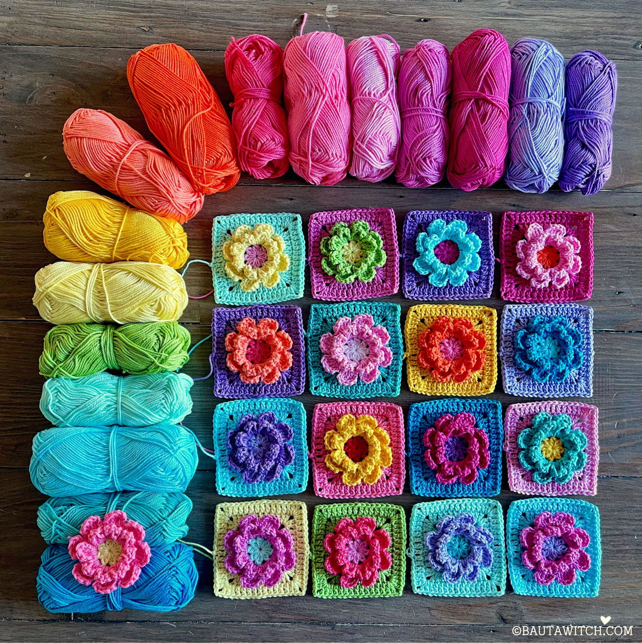 Rainbow yarn skeins arranged with colorful crochet granny squares featuring flower patterns on wood surface