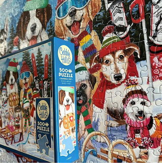 Stacked puzzle boxes with colorful dog illustrations in winter clothing