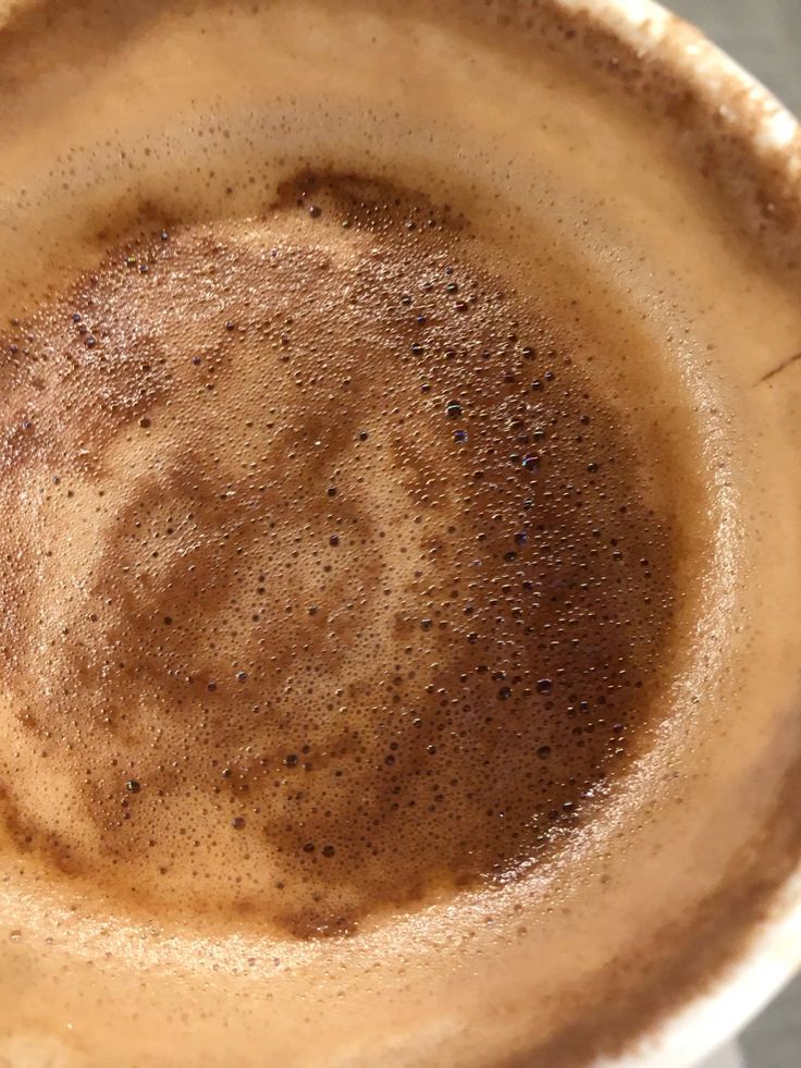 Close-up of cappuccino with brown coffee foam and crema in a cup