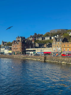 Harborfront buildings at Oban beside calm blue water under a clear sky