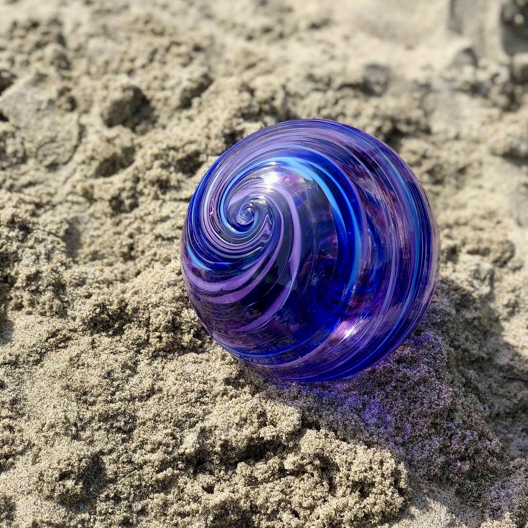 Purple Glass Sphere on Sand
